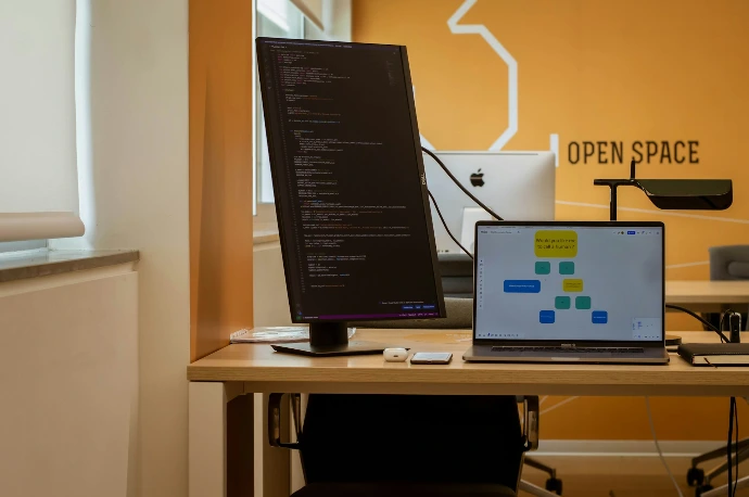 a laptop computer sitting on top of a wooden desk